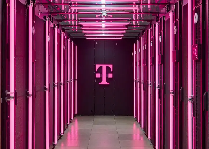 The Deutsche Telekom T logo illuminated with magenta neon light (photo)