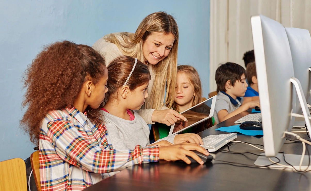 Teacher with pupils in a computer class (Photo)